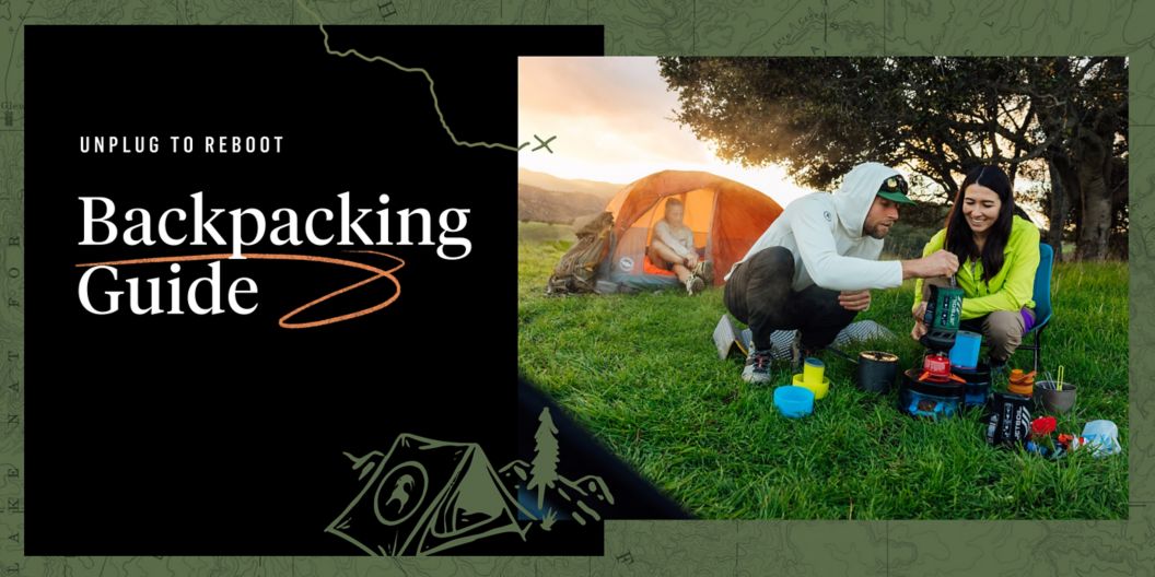 Two people prepare a meal with a backpacking stove as the sun sets behind a woman in a tent. Text overlay reads: Unplug to reboot, Backcountry Camping Guide.